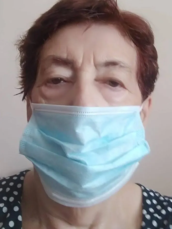 A woman wearing a face mask, with only her eyes and upper face visible