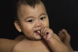 A young child resting a thumb near their mouth